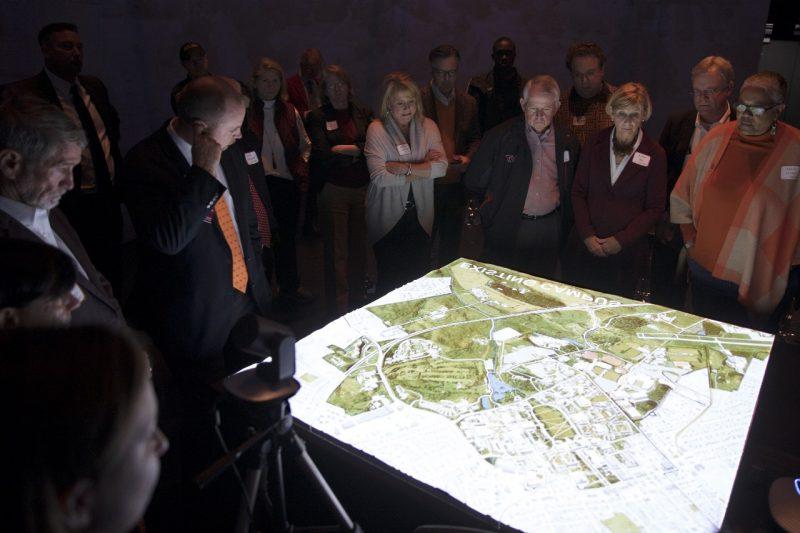Members of the Virginia Tech Board of Visitors look at a table containing a map of campus